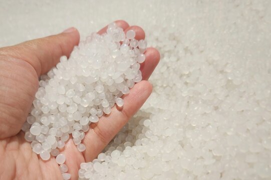 woman's hand holding plastic pellets which are used as raw material for EVA products, also used as children's toys