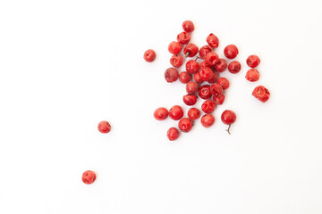 Red peppercorns on white background. Organic spice. Dry red pepper grain. 