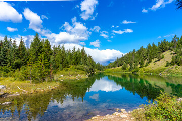 カナダ　森の中の美しい湖に反射する空と雲