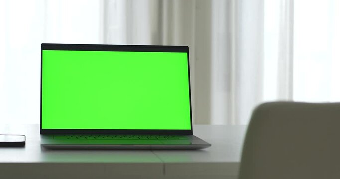 Laptop home office with green screen where you can add any image to the laptop monitor. 