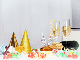 Date of Birth  92. Festive background with a bottle of champagne. Festive Champagne in glasses with gift boxes, anniversary card, happy birthday decorations in white colors