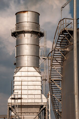 The chimney of a fossil fuel thermoelectric plant, with a stairway in the foreground