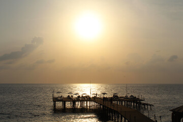 Obraz premium sunset on the beach. sea ​​pier on the background of a beautiful sunset over the sea 