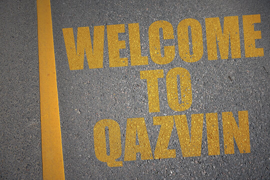 asphalt road with text welcome to Qazvin near yellow line.