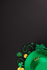 Irish cheer: a spirited St. Paddy's Day celebration. Top view vertical shot of party eyewear, traditional hat, trefoils, coins, beads on black background with greeting space