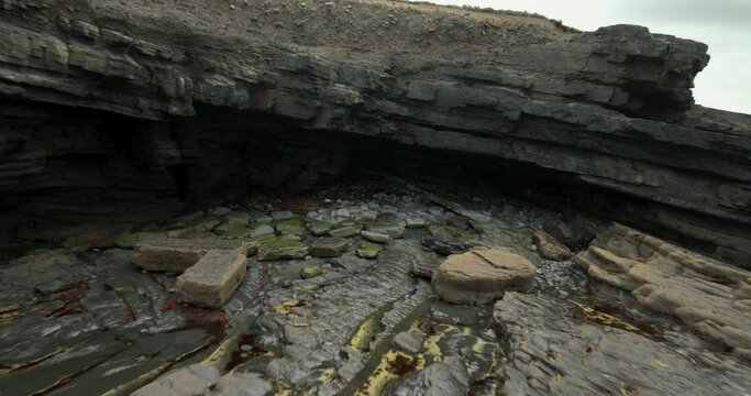 Rocky coastline near green fields in 4k