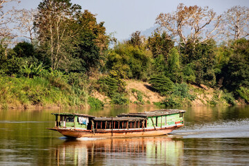 Wooden boat on its way upstream on the Mekhong River,