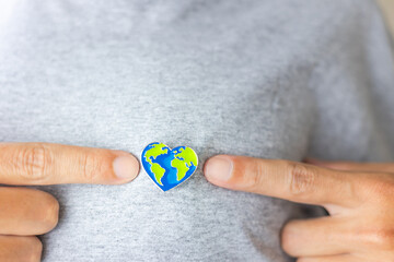 Earth Day: heart-shaped Earth pin proudly worn on a person's chest, emphasizing love for our planet...