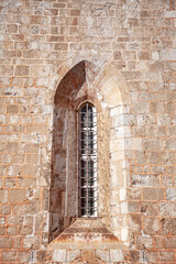 Stone wall with a church window in the old town