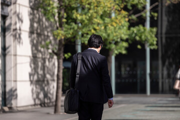 オフィス街を歩く中年サラリーマンの後ろ姿