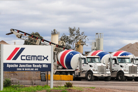 An overview of a Cemex Concrete Plant in Pinal County, Arizona, showcases ready-mix cement trucks, processing silos, and a tall pile of sand