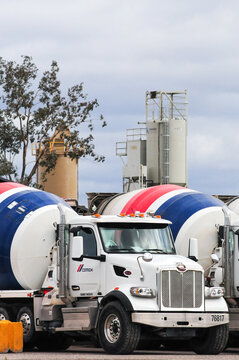 A vertical view of a Cemex Concrete plant showcasing its white, blue and red ready-mix cement trucks and processing silos at a facility in Pinal County, Arizona