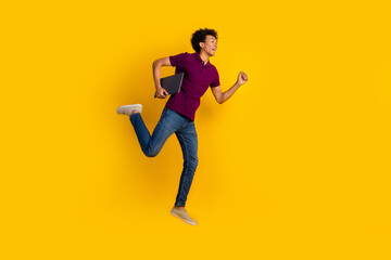 Profile side photo of crazy cheerful man wearing stylish purple clothes going fast looing empty space isolated on yellow color background
