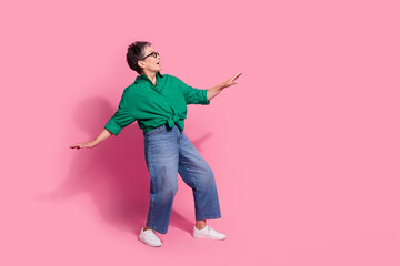 Full size photo of pretty retired female dancing celebrate promo party wear trendy green outfit isolated on pink color background
