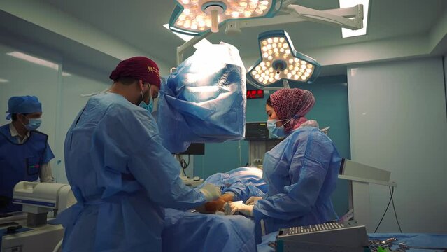 Orthopedic surgeon perform a surgery. Surgeon or doctor in blue uniform did surgery in surgical hospital with orange light effect and blur background.