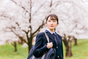 桜の中を歩く中学生・高校生・女子高生・女子高校生
