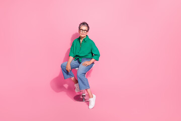 Full size photo of clever cheerful good mood person wear shirt denim trousers sit on chair at...