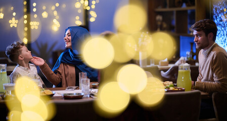 In a modern restaurant, an Islamic couple and their children joyfully await their iftar meal during the holy month of Ramadan, embodying familial harmony and cultural celebration amidst the