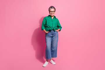 Full body photo of attractive pensioner woman posing hands pockets defile dressed stylish green...