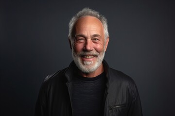 Portrait of a happy senior man in a black leather jacket on a dark background.