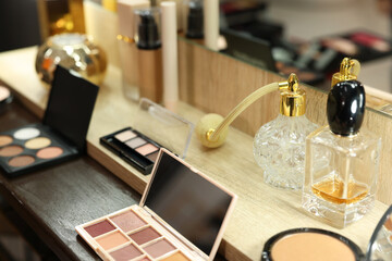 Fototapeta na wymiar Makeup room. Cosmetic products and perfumes on wooden dressing table indoors