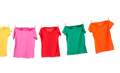 Different bright t-shirts drying on washing line against white background