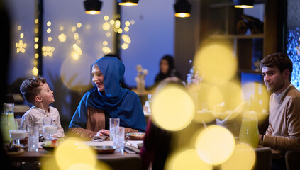 In a modern restaurant, an Islamic couple and their children joyfully await their iftar meal during...