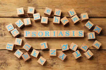 Word Psoriasis made of cubes with letters on wooden table, flat lay