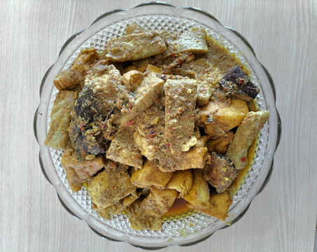 Mangut Ikan Tongkol or spicy fish curry is Javanese cuisine. Smoked tuna fish cooked with tempeh, tofu, spices and coconut milk. Focus selection. Top view.
