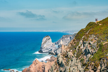 Fototapeta na wymiar Cabo da Roca's rocky cliff with a couple holding hands in the stance