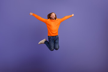 Fototapeta na wymiar Full body size photo of energetic blond hippie man wear orange sweater with jeans winner competition isolated on violet color background