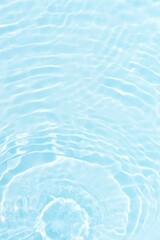 Water surface. Bluewater waves on the surface ripples blurred. Defocus blurred transparent blue colored clear calm water surface texture with splash and bubbles. Water waves with shining pattern.