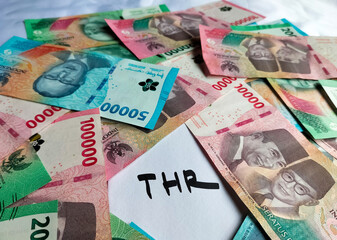 Closeup view of new edition of Indonesian banknotes in a brown envelope for THR (tunjangan hari...