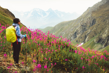 Close up smiley Caucasian woman hiker with hiking pols stand enjoy stunning mountains landscape in blooming spring nature. Solo hiking healthy lifestyle concept