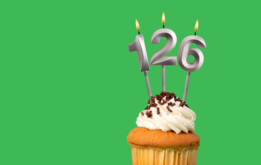 Birthday with number 126 candle and cupcake - Anniversary card on green color background