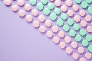 Pastel green and baby pink tablets creating a wave pattern on a lavender background. Place for text