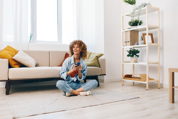 Smiling woman holding mobile phone, enjoying online gaming on cozy sofa in living room