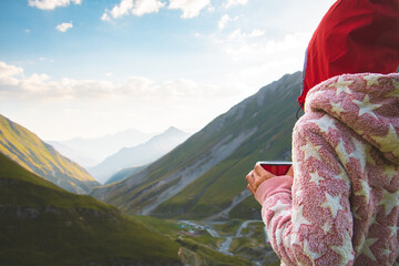 Back view thoughtful female dreamer girl in pyjamas stand on viewpoint drink fresh coffee from red...