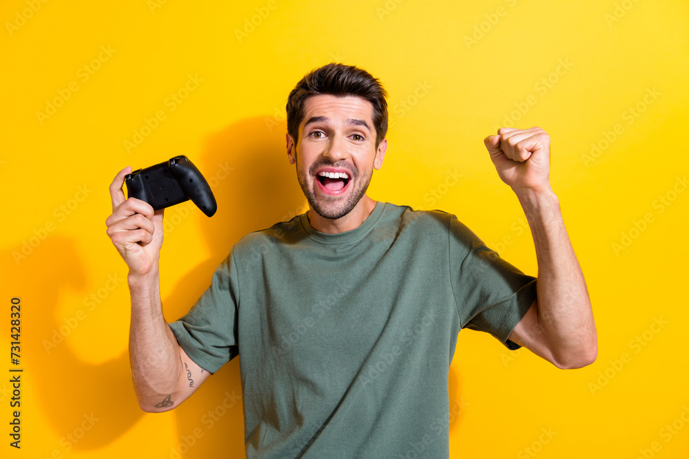 Poster portrait of satisfied guy with stubble wear stylish t-shirt hold joystick win playstation game isola