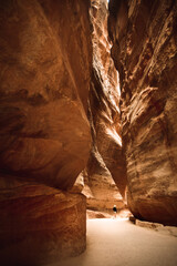 Tourist on The Siq, the narrow slot-canyon that serves as the entrance passage to the hidden city...