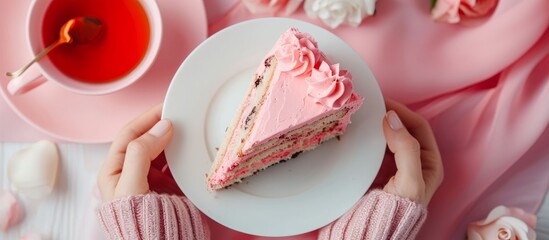 A person is holding a plate with a slice of sugar cake, a delicious dessert, showcasing it on pink dishware.