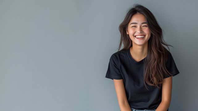 Asian young woman wear black t-shirt smile isolated on grey background