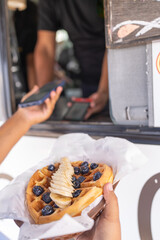Man paying a waffle using mobile contactless payment
