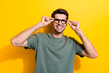 Portrait of intelligent positive guy wear stylish t-shirt fingers touching glasses at checkup...
