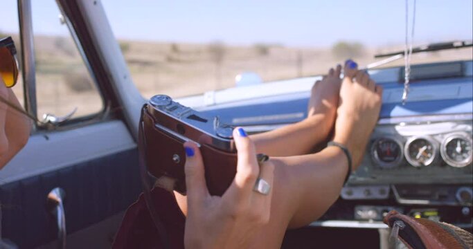 Legs on dashboard, car and photo on road trip, travel or relax on adventure closeup. Hands, camera and vehicle for journey in transport, vacation or person take picture on holiday in the countryside