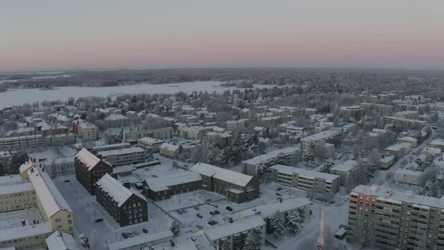 Aerial view of the buildings of Vaasa city covered with snow during winter season at sunset, Finland
