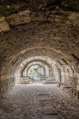 View through a stone arched passageway at a historical site with cobblestone ground in Izmir, Turkiye.