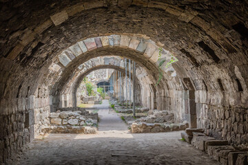 A series of stone arches forming a corridor within an ancient structure in Izmir, Turkiye.