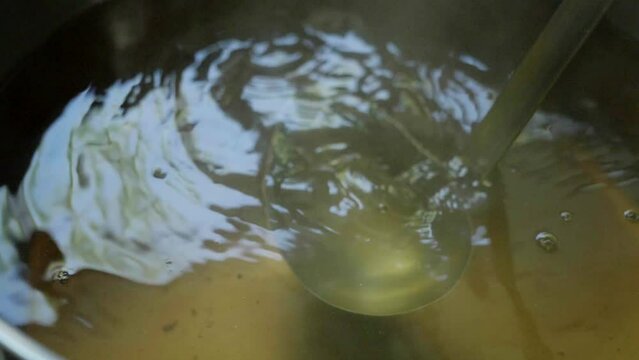 金色に輝く出汁のスープをかきまぜるスローモーション　和食・日本・料理・旅行