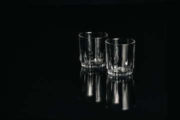Black and white isolated empty Whiskey drinking crystal clear glasses with reflections and space for text